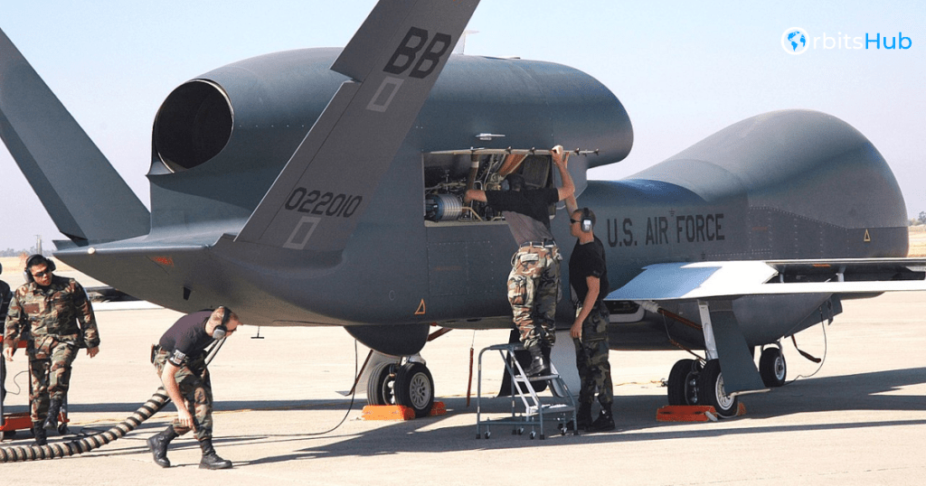 U.S. Air Force technicians working on the tail section of a Northrop Grumman RQ-4 Global Hawk drone on an airfield
